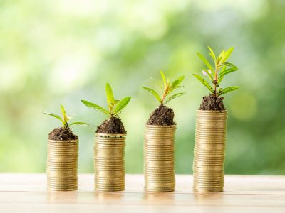 Coin on wooden table in front of green bokeh background. coins a concept of investment and saving moneys.